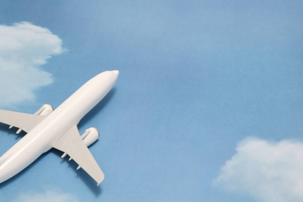 istock Miniature toy airplane on blue sky with clouds. Trip by airplane. 687422378