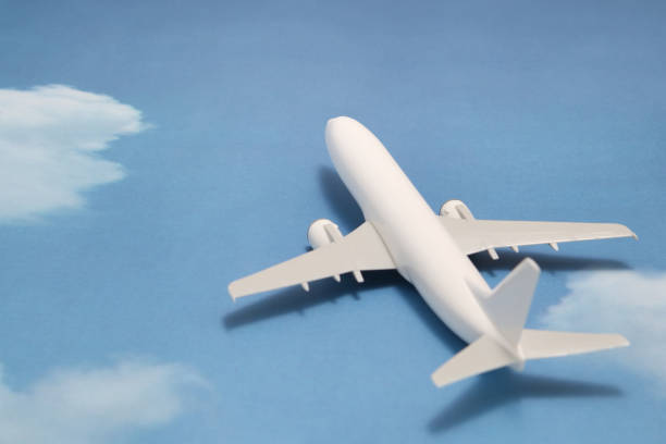 istock Miniature toy airplane on blue sky with clouds. Trip by airplane. 687422382