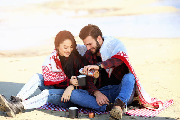 istock Loving young couple on the beach pouring coffee 687425606