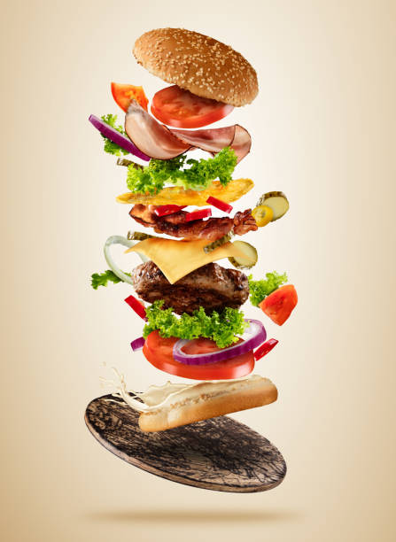 istock Flying burger ingredients above wooden board on brown background 687425742