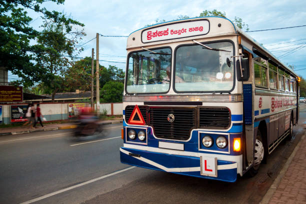 A blue and white bus parked by the side of the road in Anuradhapura, Sri Lanka. stock photo