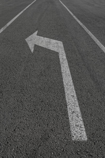 istock Turn left white arrow sign on road. 687438004
