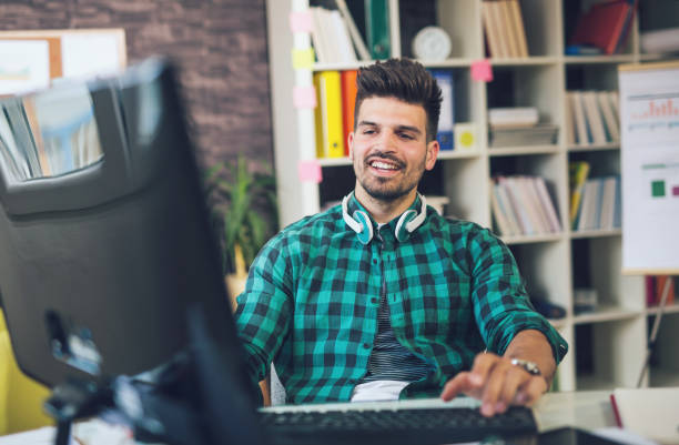 istock Handsome caucasian man at work desk facing flat screen computer in office 687442112