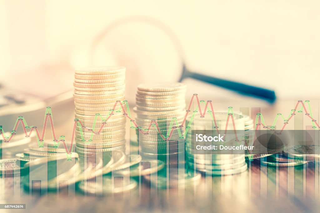 double exposure of coins and stock graph business concept in vintage tone double exposure of coins and stock graph business concept with magnifying glass and calculator in background in vintage tone Magnifying Glass Stock Photo