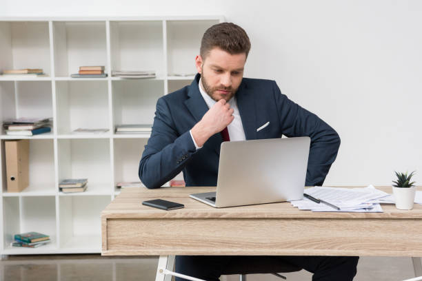 istock Confident businessman sitting at table with laptop in office 687442718
