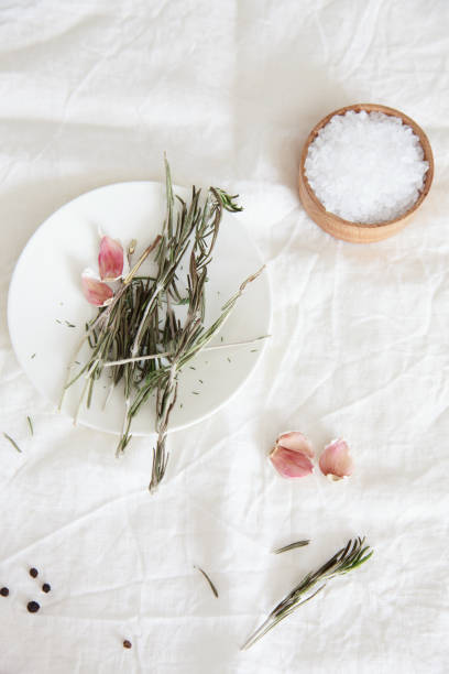 istock Rosemary stems and garlic cloves lie on a white plate on a light 687445440