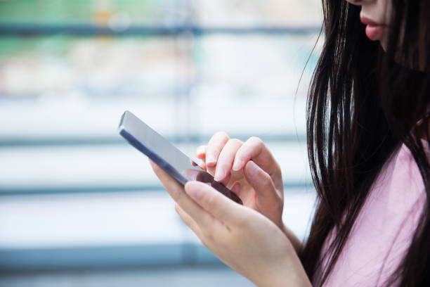 istock Young woman hand holding mobile phone 687447012