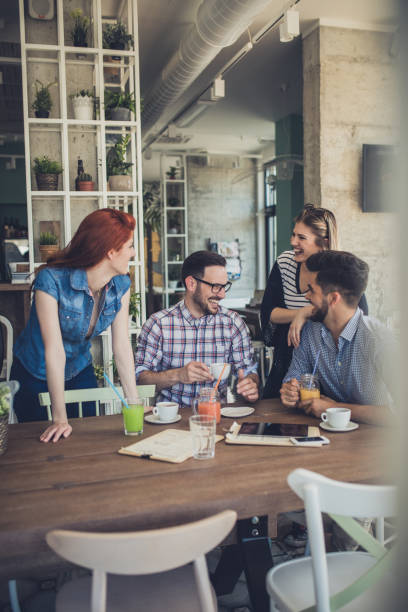 istock Young people laughing while relaxing in a cafe and communicating. 687450378