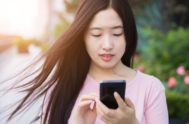 istock Young woman holding mobile phone 687455944