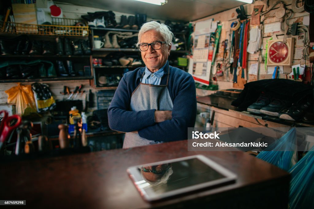 Portrait of cobbler Portrait of a senior man who works as a shoemaker in his cobbler's workshop Owner Stock Photo