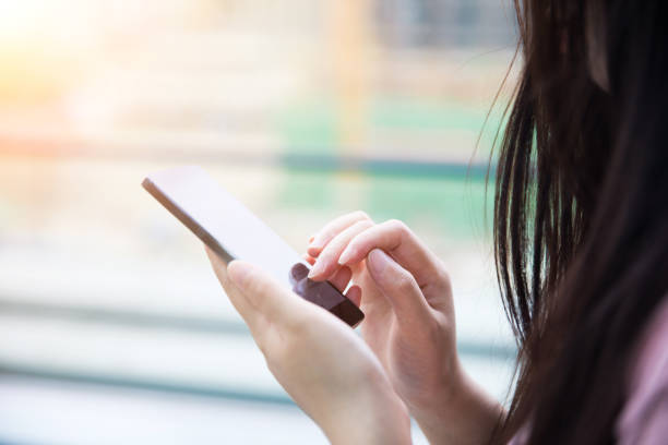 istock Young woman hand holding mobile phone 687459508