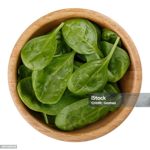 Hojas De Espinacas Bebé Fresco En Recipiente De Madera Aislada Sobre Fondo Blanco Vista Superior Foto de stock y más banco de imágenes de Cuenco