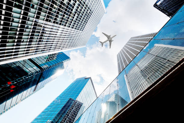 istock Airplane flying over business skyscrapers 687472528