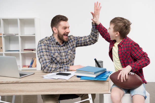 istock Businessman freelancer with his son wit ball at home office 687483028