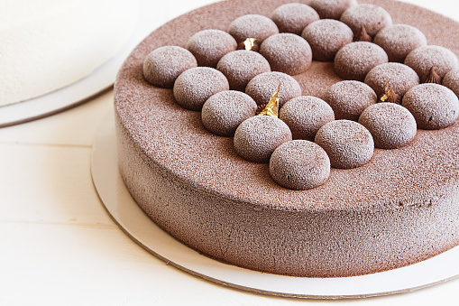 Frozen mousse cake covered with chocolate velour. Modern european cake.