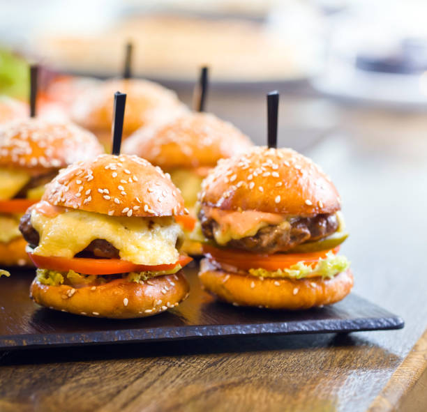 istock Burgers on wooden table in restaurant . 687483934