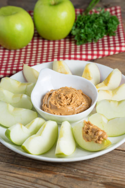 istock Green apple sliced with peanut butter. 687483998