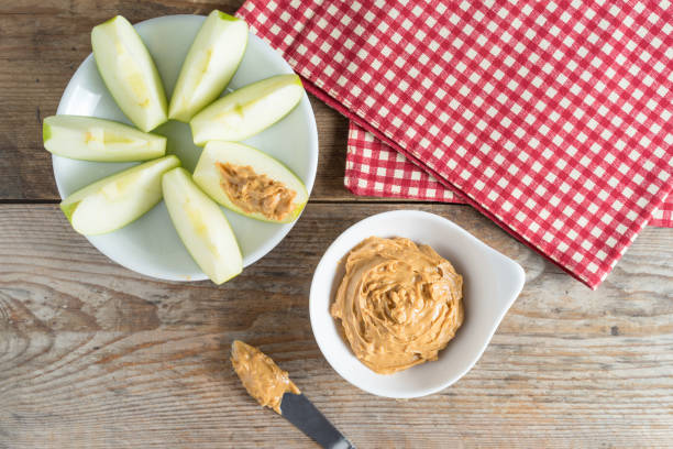 istock Green apple sliced with peanut butter. Top view. 687484154