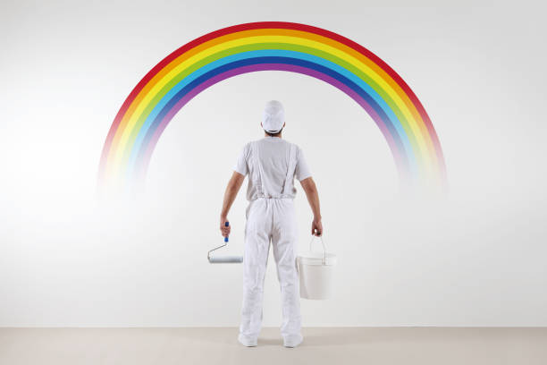 istock Rear view of painter man looking rainbow at blank wall, with paint roller and bucket, isolated on white 687498786