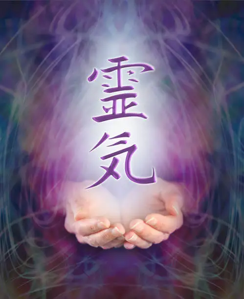 Female cupped hands with the Japanese Reiki Symbol floating above on a swirling misty energy purple background