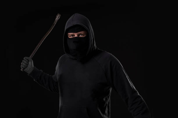 istock Male offender masked with a scrap. On black background at the studio 687511024