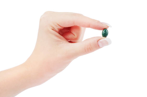 istock close up round white pill in hand 687511756