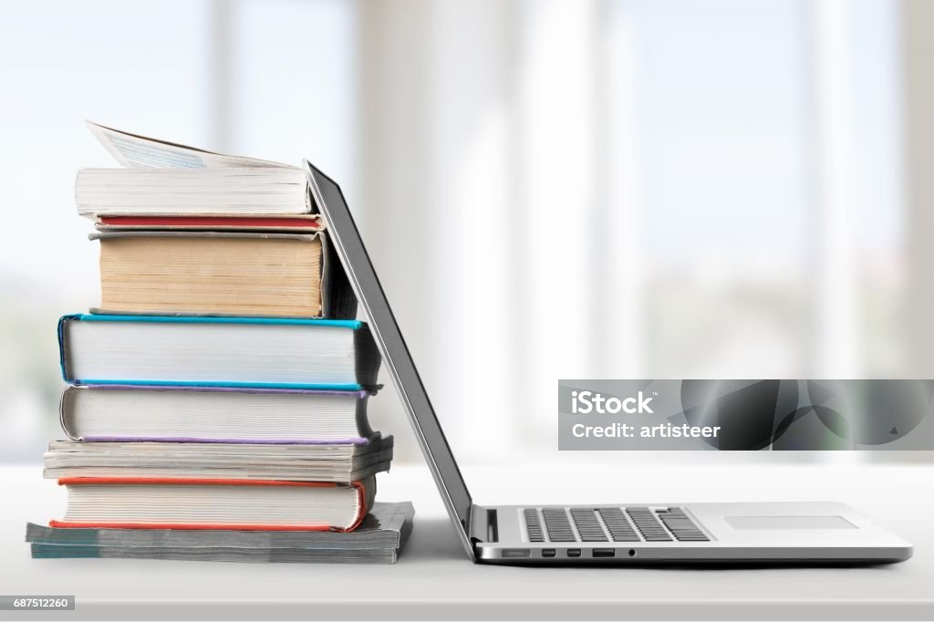 Education. Stack of books with laptop on table Book Stock Photo