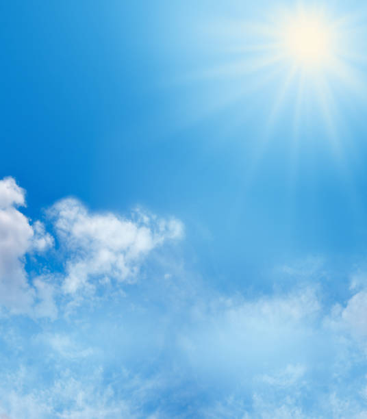 Blue Sky and Sunshine Background Big bright sunburst in right top corner, large copy space on left side with soft fluffy clouds in bottom third of image and more copy space sunny stock pictures, royalty-free photos & images