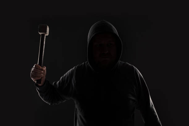 istock Criminal in dark clothes and balaclava with hammer 687514824