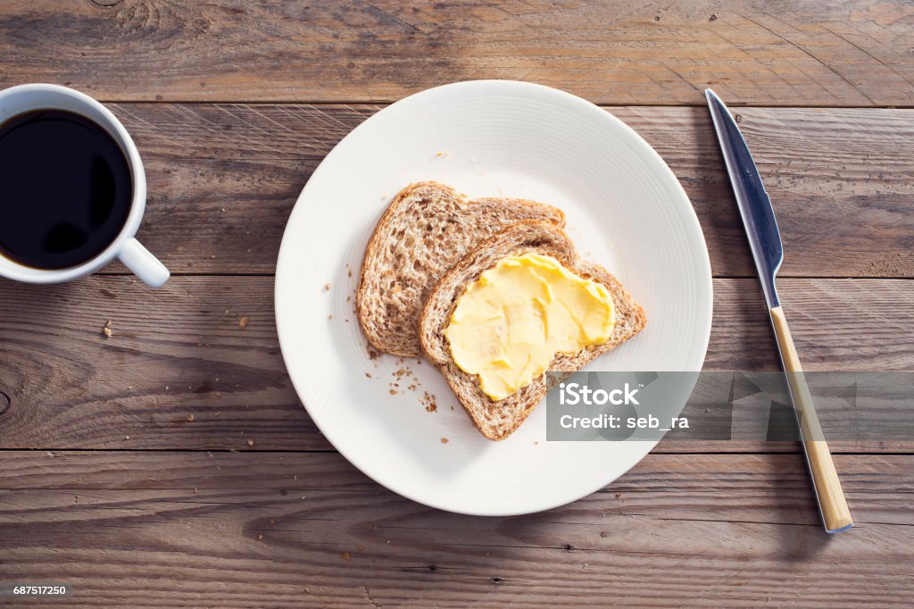 Slices bread with butter on wooden table Butter Stock Photo