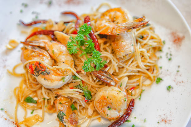 Spicy Shirmp Garlic Pasta on white plate, sunlight daylight.