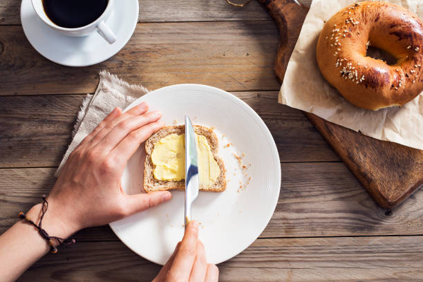 istock Woman hand spreading butter on sliced bread 687519758