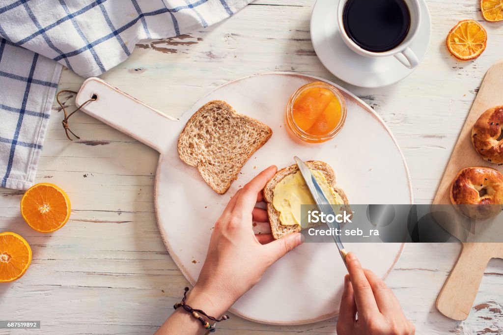 얇게 썬 빵에 버터를 퍼뜨리는 여성 - 로열티 프리 버터 스톡 사진