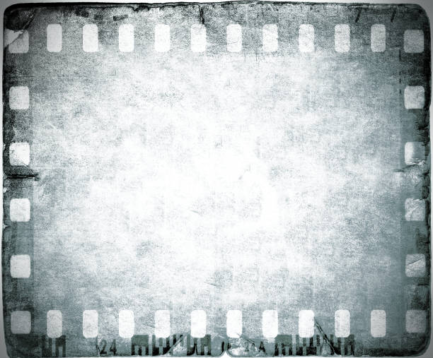 istock Vintage film strip frame on old and damaged paper background. 687524008