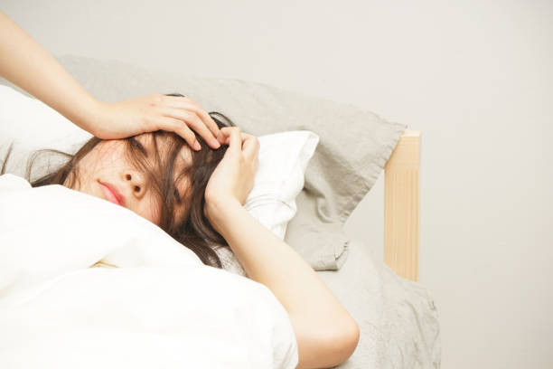 若い女性がベッドで横になって - 目がさめる 日本人 ストックフォトと画像