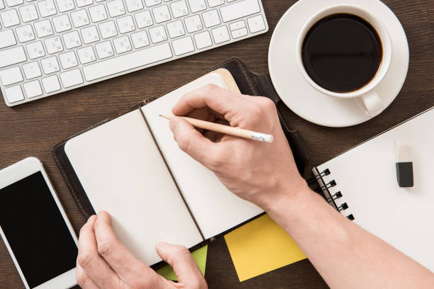 istock top view of man writing in notebook on home office table 687530560