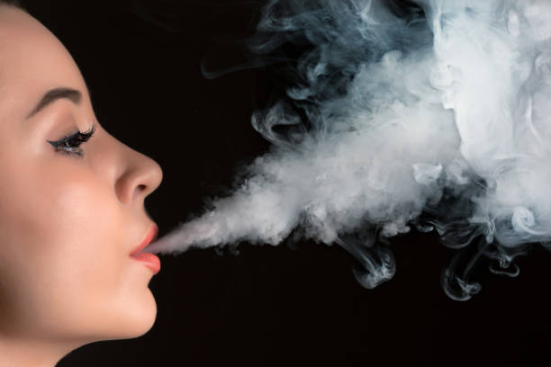 istock The face of vaping young woman at black studio 687530646