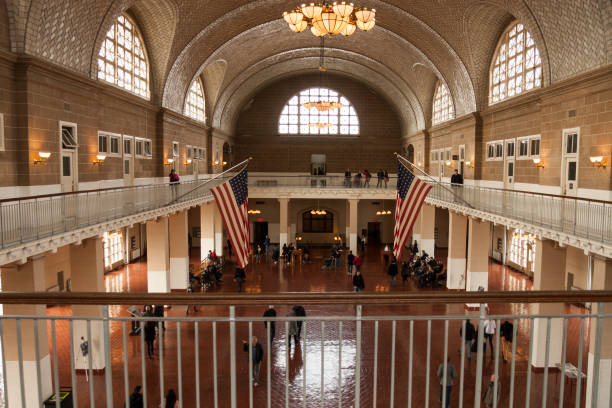 New York City, USA - December 1, 2014: View of the Great Hall at historic landmark Ellis Island immigrant gateway with people visible. This notable tourist attraction was the gateway for millions of immigrants to the United States as the nation's busiest immigrant inspection station from 1892 until 1954.