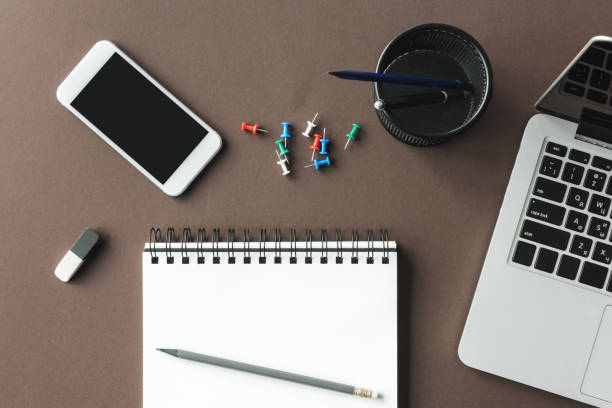 istock Top view of laptop, empty notebook and smartphone with blank screen at workplace, small office concept 687533738