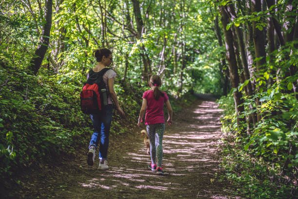 istock Mother and daughter walking on path in woods 687536334