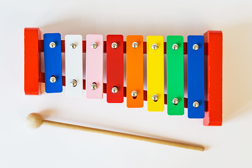 Top view of colorful xylophone toy, on a white table. Isolation in white.