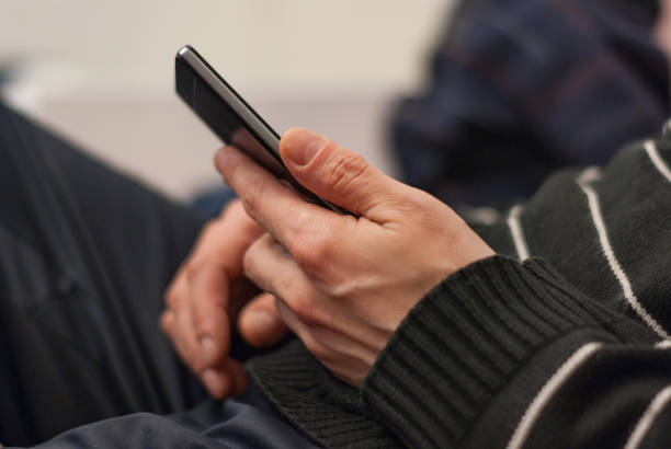 istock A young man sitting on the couch to rest with a smartphone in hand. 687541438