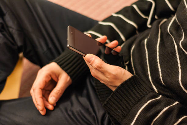 istock A young man sitting on the couch to rest with a smartphone in hand. 687541466