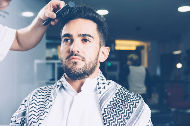 istock Barber combing man in salon 687552934