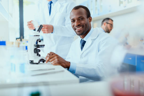 jovens médicos fardado trabalhando no laboratório, técnicos de laboratório de ensaio - separating laboratory - fotografias e filmes do acervo