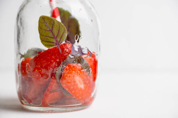 Empty jar of cocktail with strawberry and basil. Shallow depth of field.