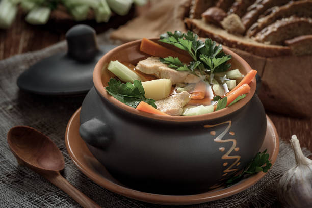 istock soup in pot, bread, wooden spoon on the table closeup 687560036