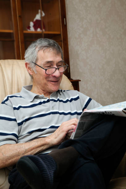 istock Retired senior man doing crossword in newspaper 687560608
