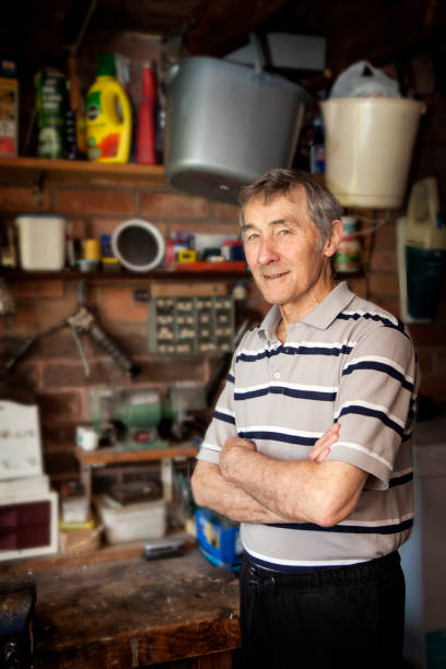 istock Retired man stood in garage with his arms crossed and smiling 687560736