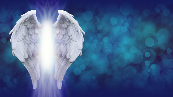 Wide blue bokeh background with a large pair of Angel Wings on the left side and a shaft of bright light between